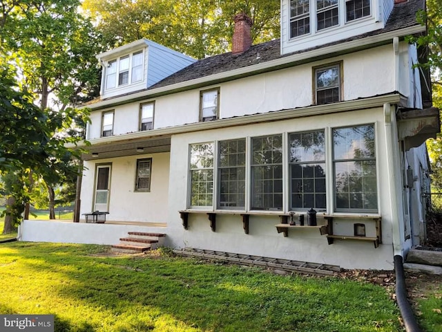 rear view of property featuring a yard