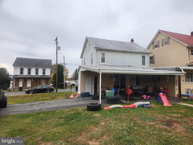 rear view of property with covered porch and a yard