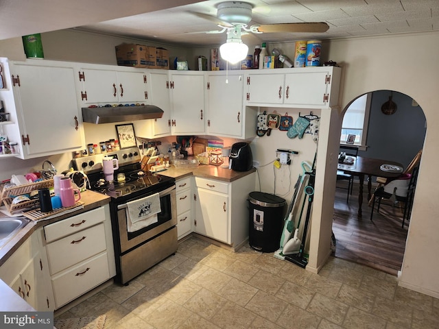 kitchen with electric range, white cabinetry, ceiling fan, and ornamental molding