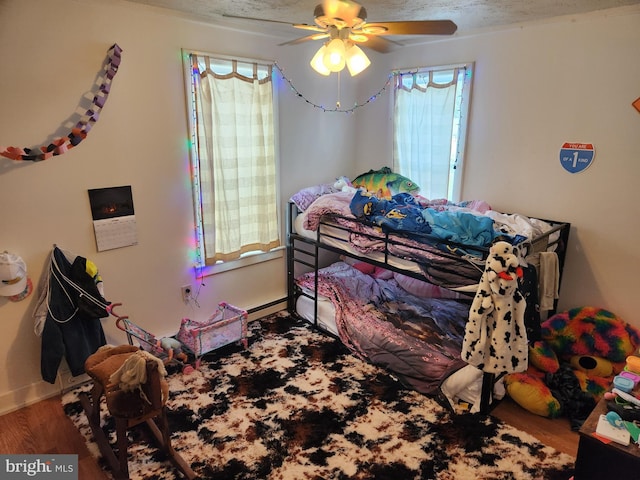 bedroom featuring ceiling fan, hardwood / wood-style floors, and a textured ceiling