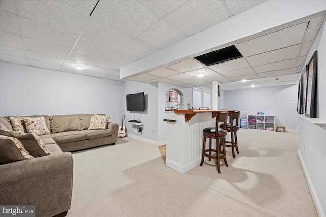 living room with a paneled ceiling and carpet floors