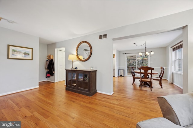 living room featuring a chandelier and light hardwood / wood-style floors