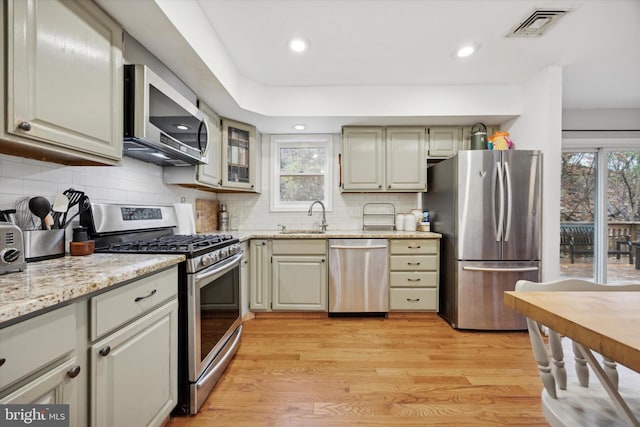 kitchen featuring a wealth of natural light, light hardwood / wood-style flooring, stainless steel appliances, and sink