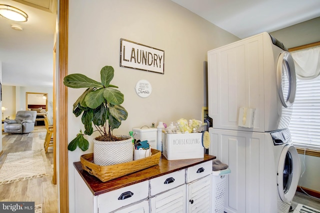 washroom featuring stacked washing maching and dryer and light hardwood / wood-style floors