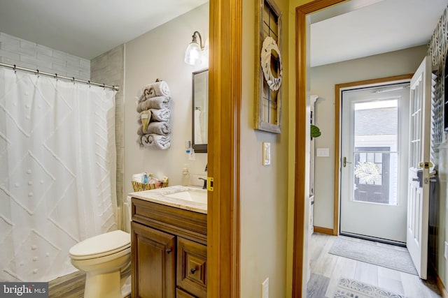 bathroom featuring hardwood / wood-style flooring, vanity, toilet, and a shower with shower curtain