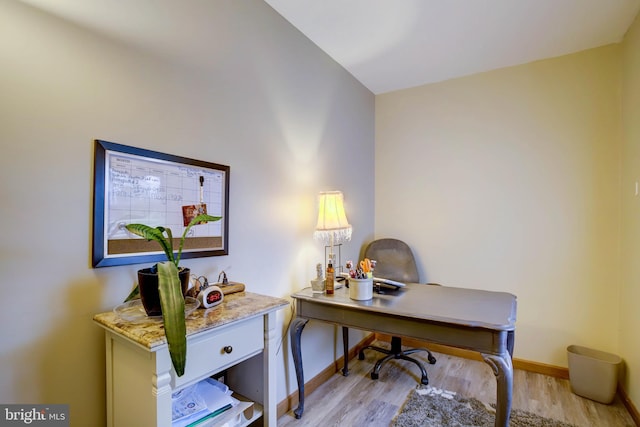 office space with vaulted ceiling and light hardwood / wood-style flooring