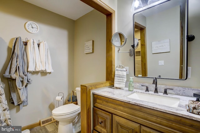 bathroom with vanity, toilet, and wood-type flooring