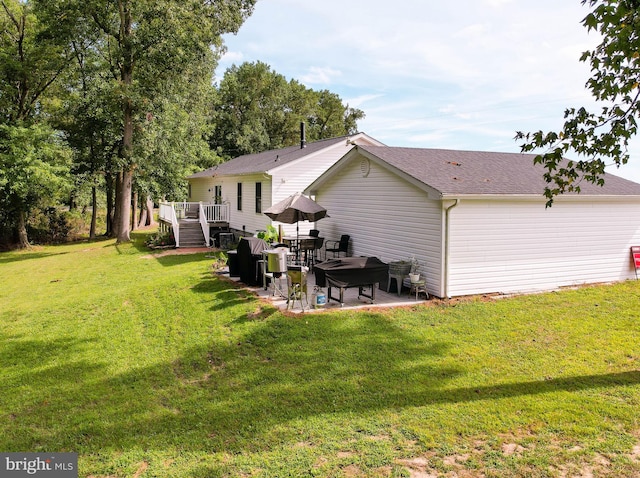 rear view of house with a lawn, a patio area, and a wooden deck
