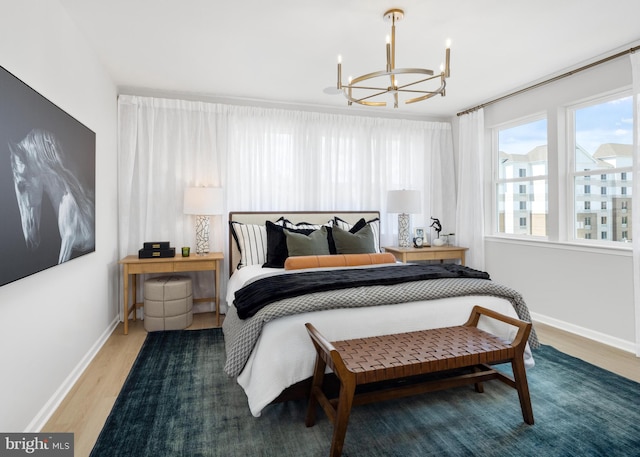 bedroom with wood-type flooring and an inviting chandelier