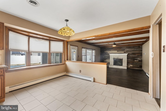 unfurnished living room with a baseboard heating unit, ceiling fan, light tile patterned floors, a fireplace, and beam ceiling