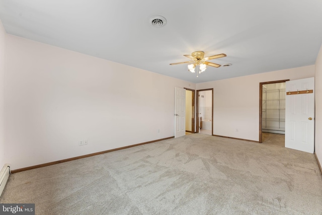 carpeted spare room with ceiling fan and a baseboard heating unit