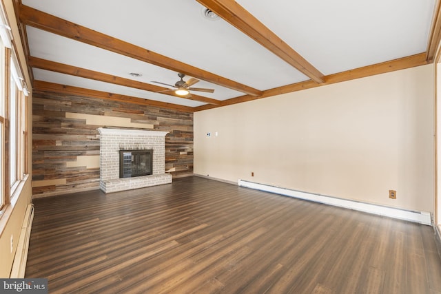 unfurnished living room featuring wood walls, ceiling fan, a baseboard radiator, beam ceiling, and dark hardwood / wood-style flooring