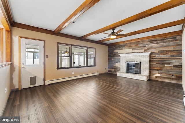 unfurnished living room featuring ceiling fan, a baseboard heating unit, beamed ceiling, a fireplace, and dark hardwood / wood-style floors