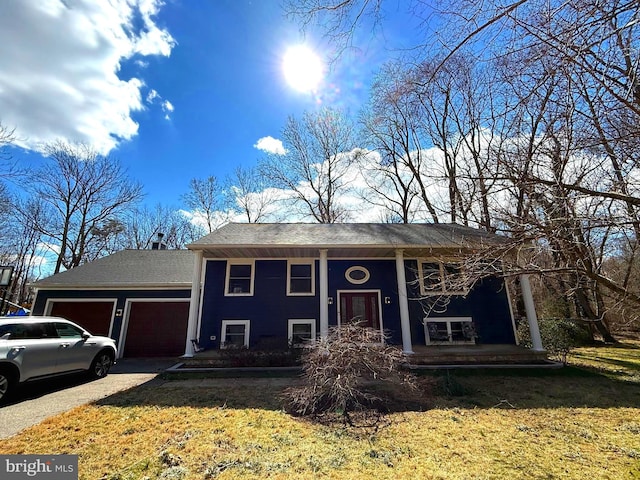 bi-level home featuring a front yard, driveway, and an attached garage