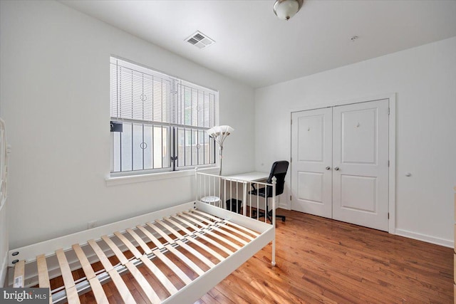 bedroom with hardwood / wood-style floors and a closet