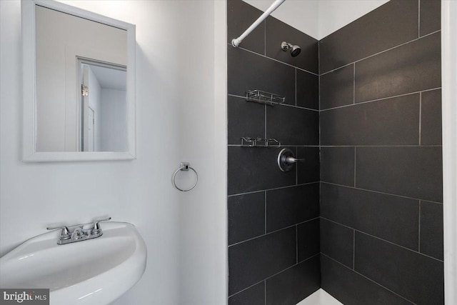 bathroom featuring a tile shower and sink