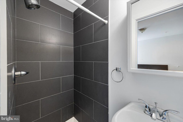 bathroom with a tile shower and sink