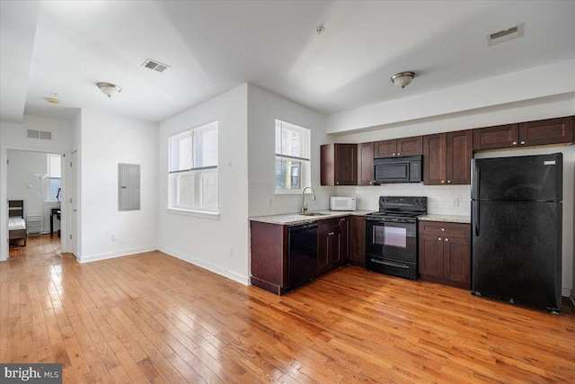 kitchen with sink, light hardwood / wood-style floors, backsplash, and black appliances