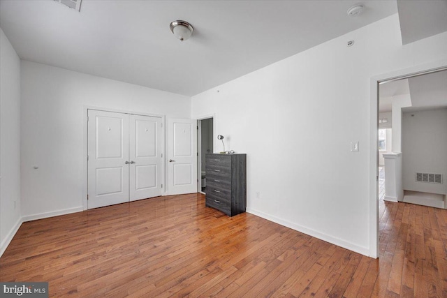 unfurnished bedroom featuring a closet and hardwood / wood-style floors