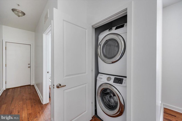 washroom featuring stacked washer and dryer and hardwood / wood-style flooring