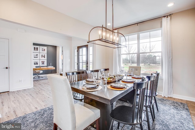 dining room with hardwood / wood-style floors and an inviting chandelier