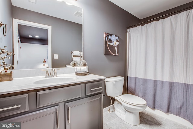 bathroom with tile patterned flooring, vanity, and toilet