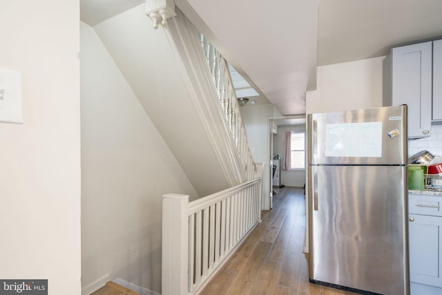 hall featuring light hardwood / wood-style floors and vaulted ceiling