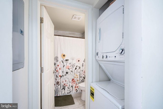 clothes washing area with stacked washer and dryer