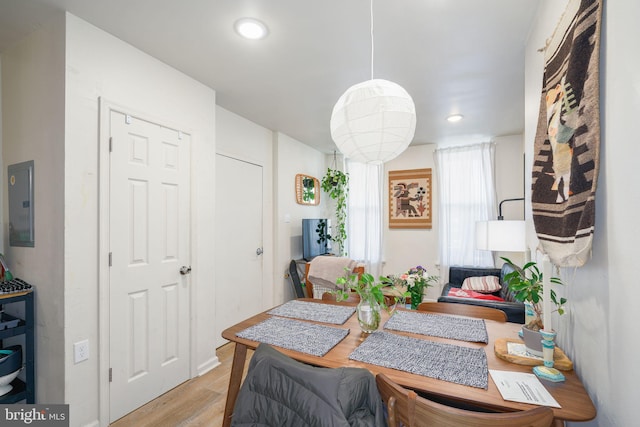 dining space featuring electric panel and light hardwood / wood-style flooring