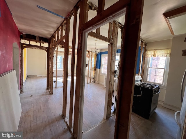 hall with hardwood / wood-style floors and an inviting chandelier