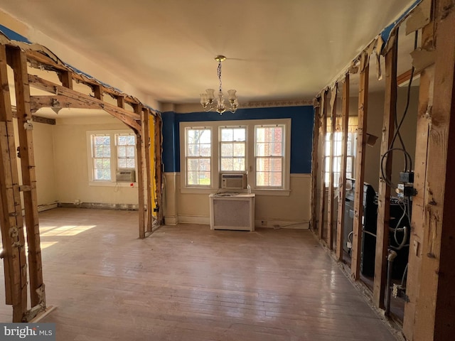 interior space with hardwood / wood-style flooring, cooling unit, and an inviting chandelier