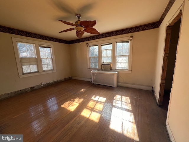 empty room with baseboard heating, ceiling fan, cooling unit, hardwood / wood-style floors, and radiator heating unit