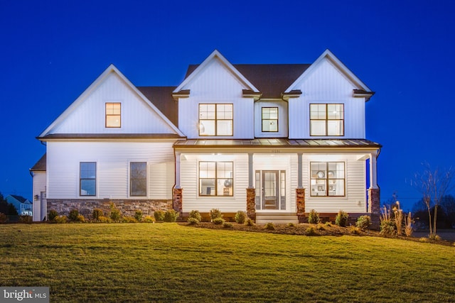 modern inspired farmhouse with a front yard and a porch