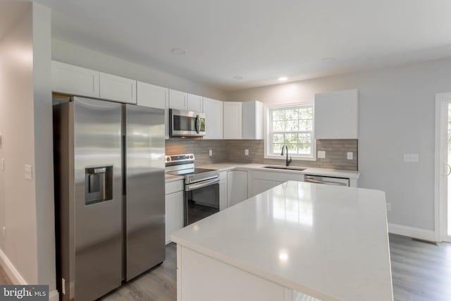 34039 Chippiwa Dr, Dagsboro, DE 19939 - kitchen with appliances with stainless steel finishes, a sink, decorative backsplash, light wood-type flooring, and recessed lighting