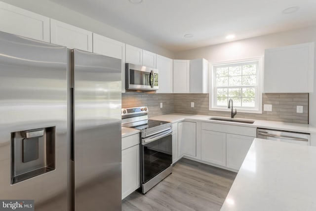 34039 Chippiwa Dr, Dagsboro, DE 19939 - kitchen featuring stainless steel appliances, a sink, light countertops, white cabinetry, and light wood-style flooring