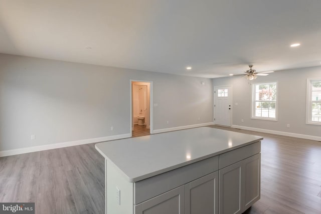 kitchen with a center island, light hardwood / wood-style floors, ceiling fan, and gray cabinetry