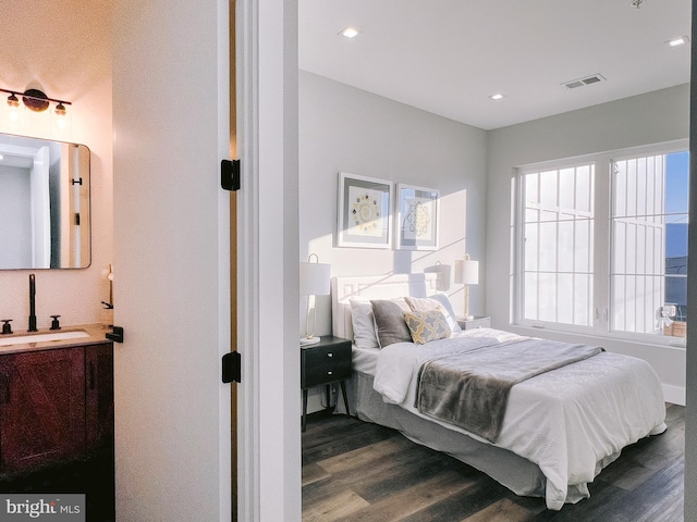 bedroom with sink and dark wood-type flooring