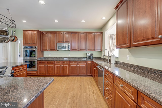 15280 Riding Club Dr, Haymarket, VA 20169 - kitchen with stainless steel appliances, a sink, light wood-style flooring, recessed lighting, and dark stone counters