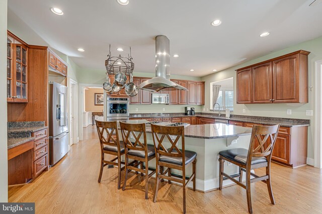15280 Riding Club Dr, Haymarket, VA 20169 - kitchen featuring island exhaust hood, stainless steel appliances, a sink, a kitchen breakfast bar, and a center island