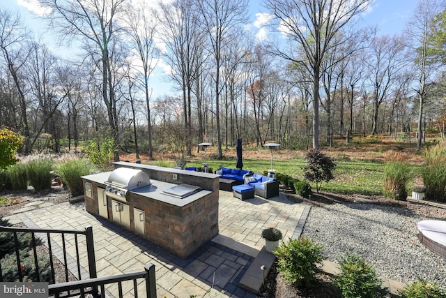 view of patio featuring an outdoor kitchen, an outdoor hangout area, and a grill