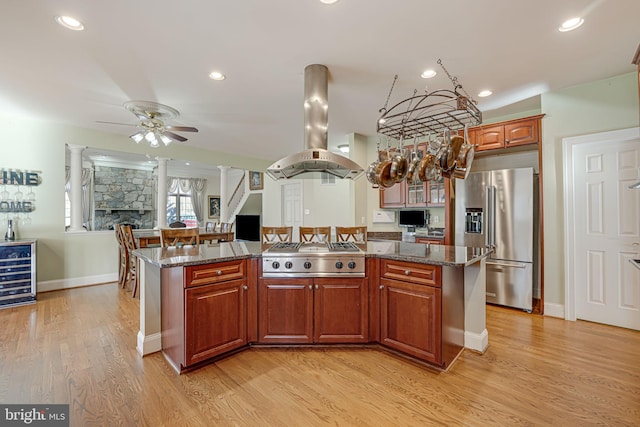 kitchen with ceiling fan, light wood-type flooring, appliances with stainless steel finishes, a kitchen island, and island exhaust hood