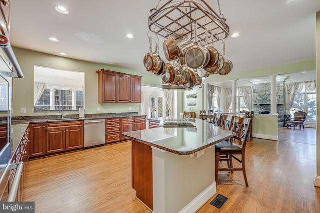 kitchen with a breakfast bar area, sink, plenty of natural light, and light wood-type flooring