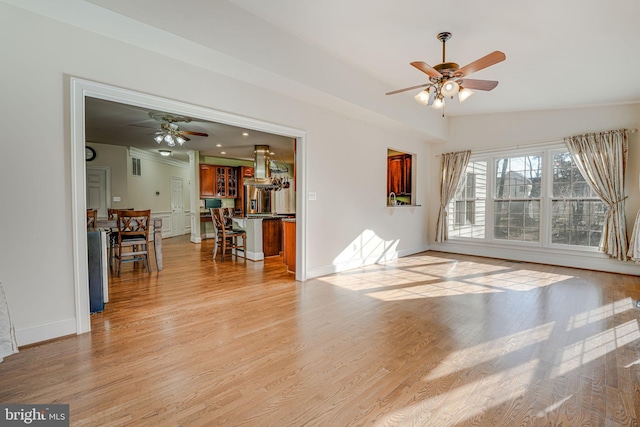 living room featuring ceiling fan, lofted ceiling, and light wood-type flooring