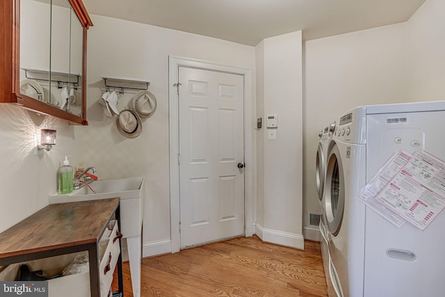 washroom featuring light hardwood / wood-style floors and washing machine and clothes dryer