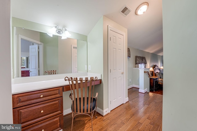 bathroom featuring ceiling fan, vanity, vaulted ceiling, and hardwood / wood-style flooring