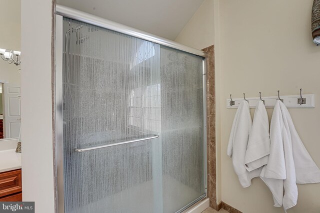 bathroom with vanity, walk in shower, and an inviting chandelier