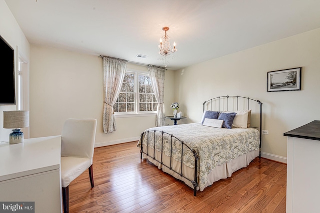 bedroom featuring hardwood / wood-style floors and a notable chandelier