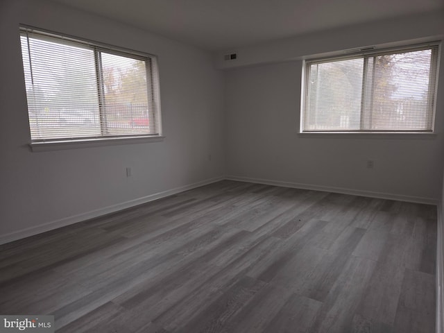 unfurnished room with dark hardwood / wood-style flooring