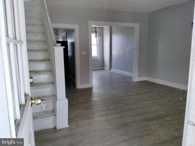 stairway with hardwood / wood-style flooring and a chandelier