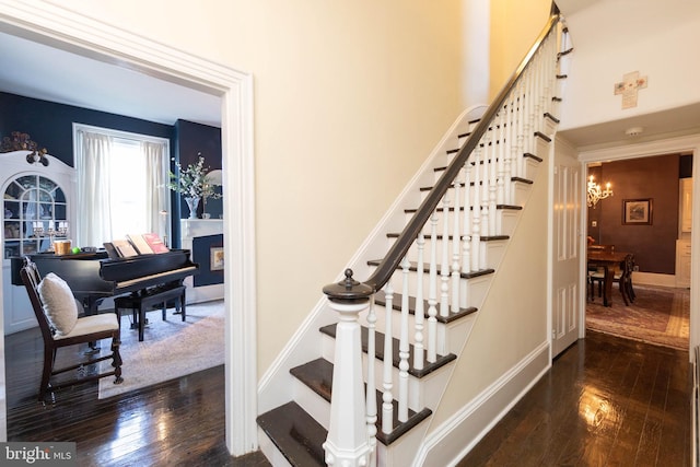 stairway featuring hardwood / wood-style flooring and a chandelier